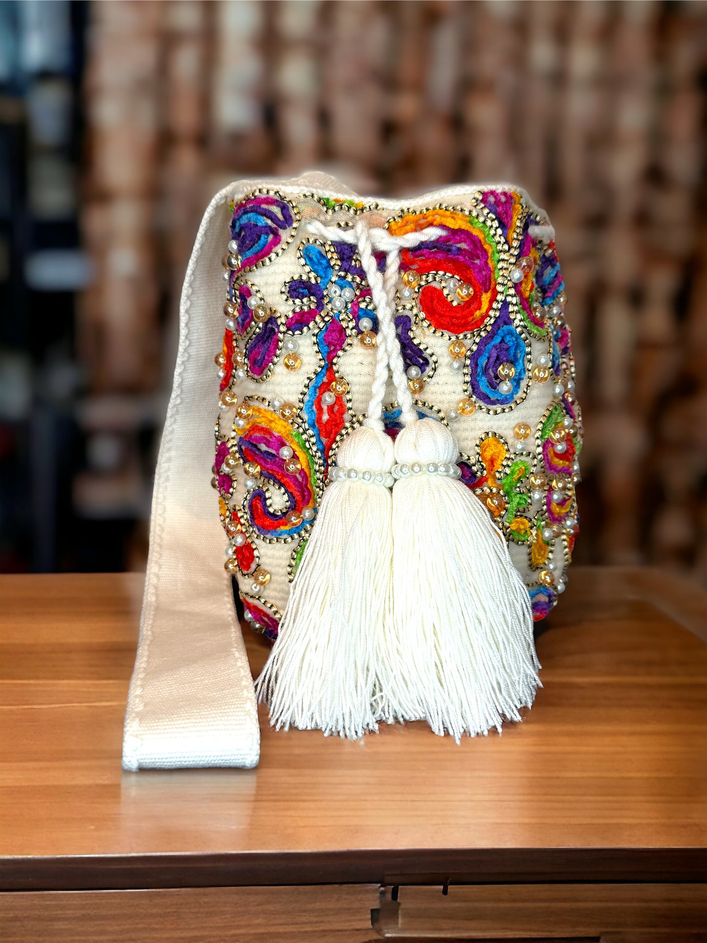 A multicolored, beaded mochila shoulder bag with a tassel, hand woven bag