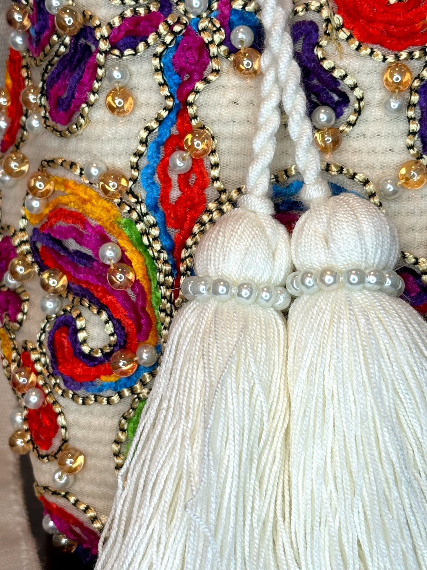 A multicolored, beaded mochila shoulder bag with a tassel, hand woven bag