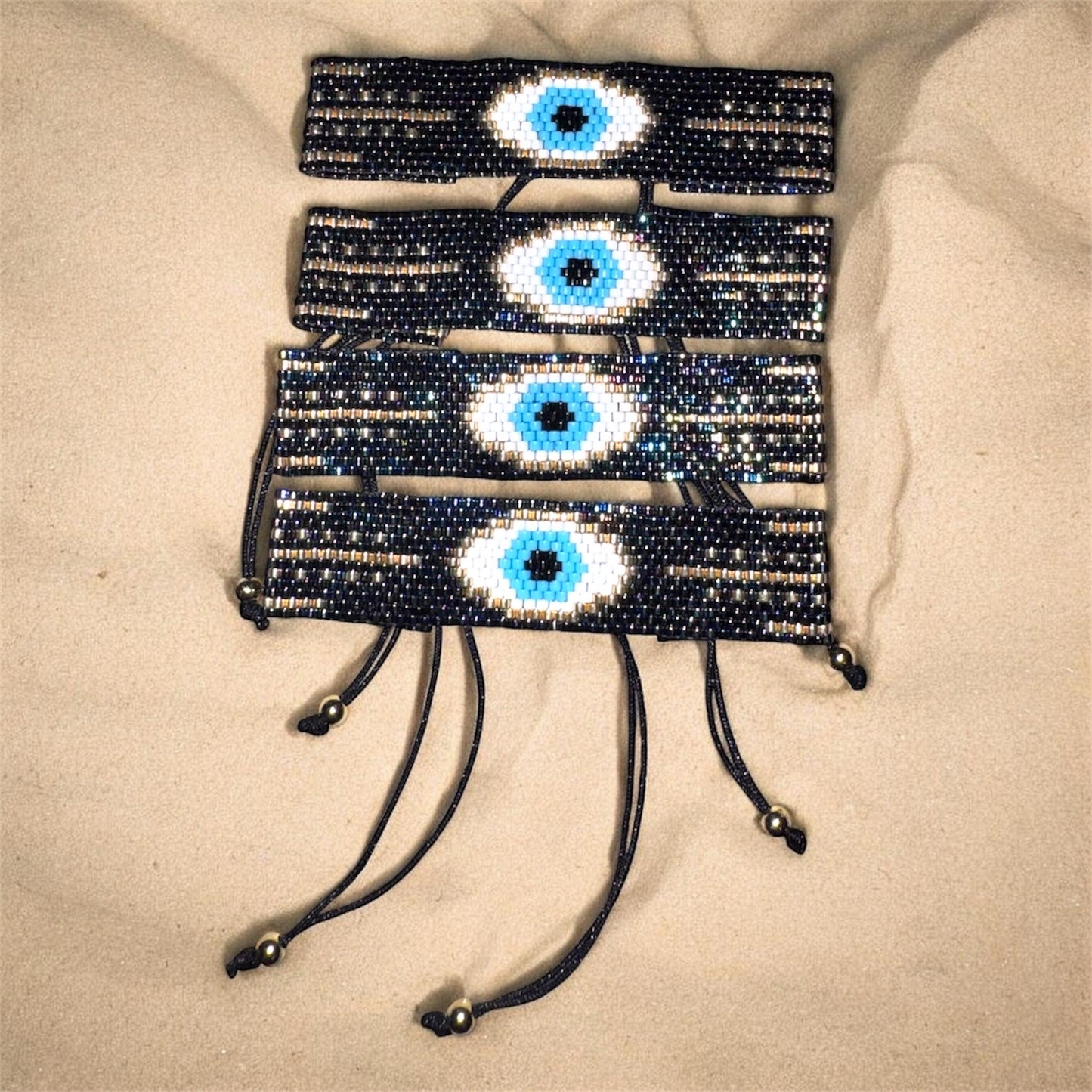 bracelets with eye designs on a beige surface