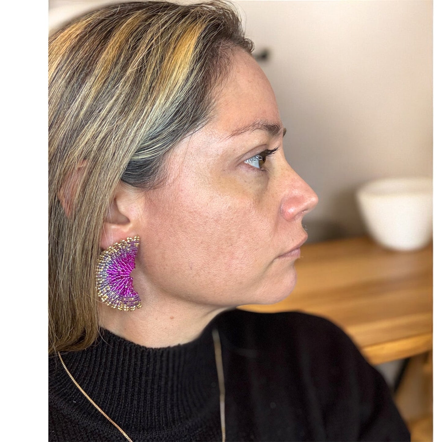 Woman wearing a colorful earring, side view