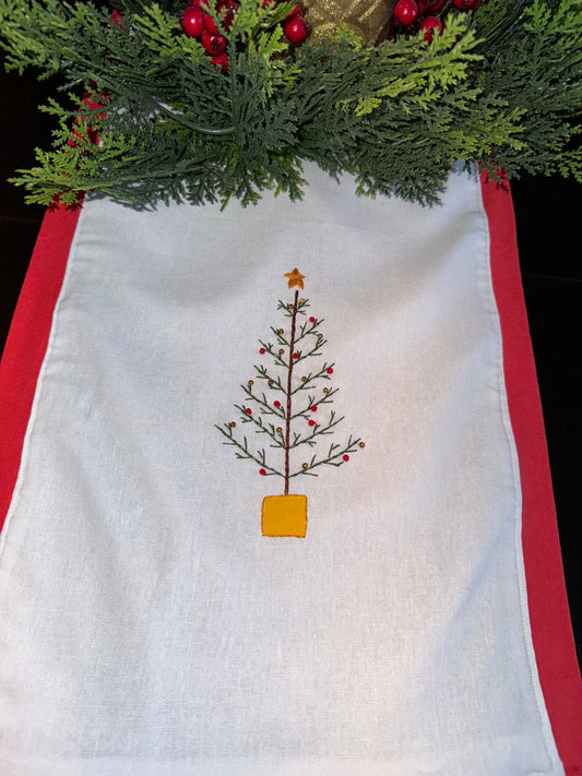 A set of white linen napkins with Christmas themed hand embroidery