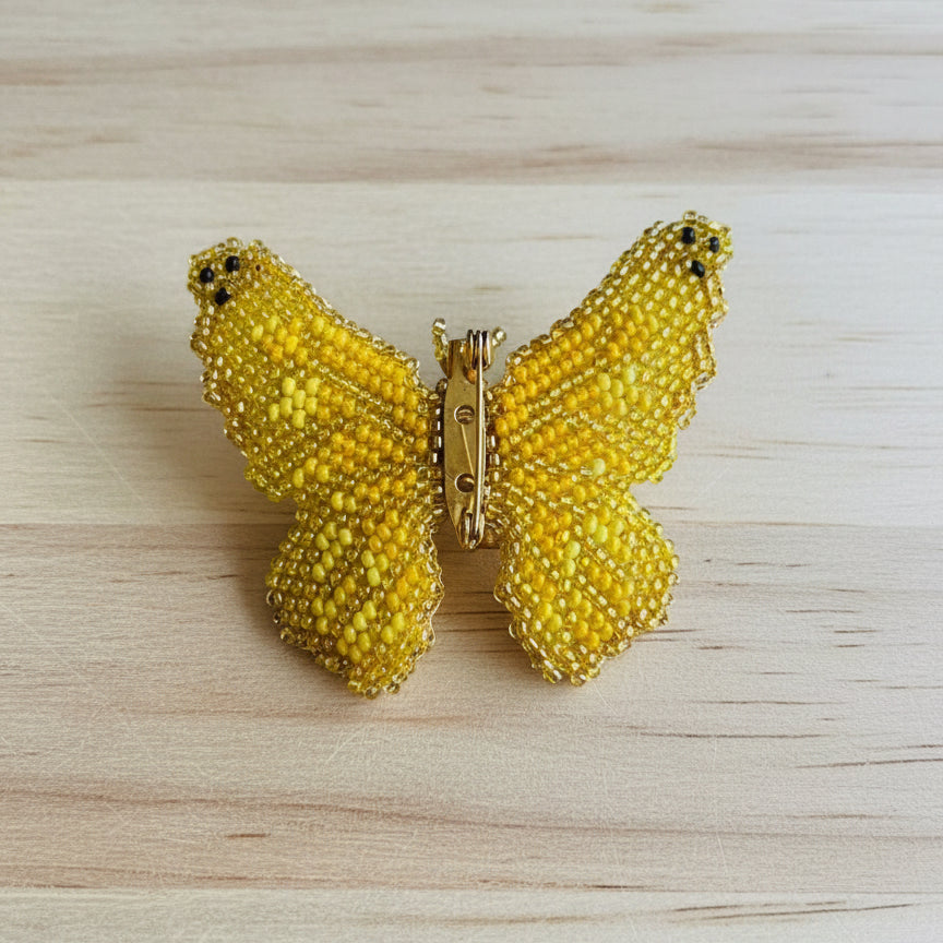Butterfly-shaped brooch with yellow and brown pattern 