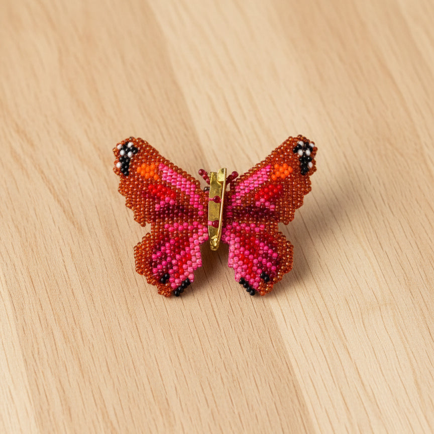 Butterfly-shaped brooch with pink and orange colors 