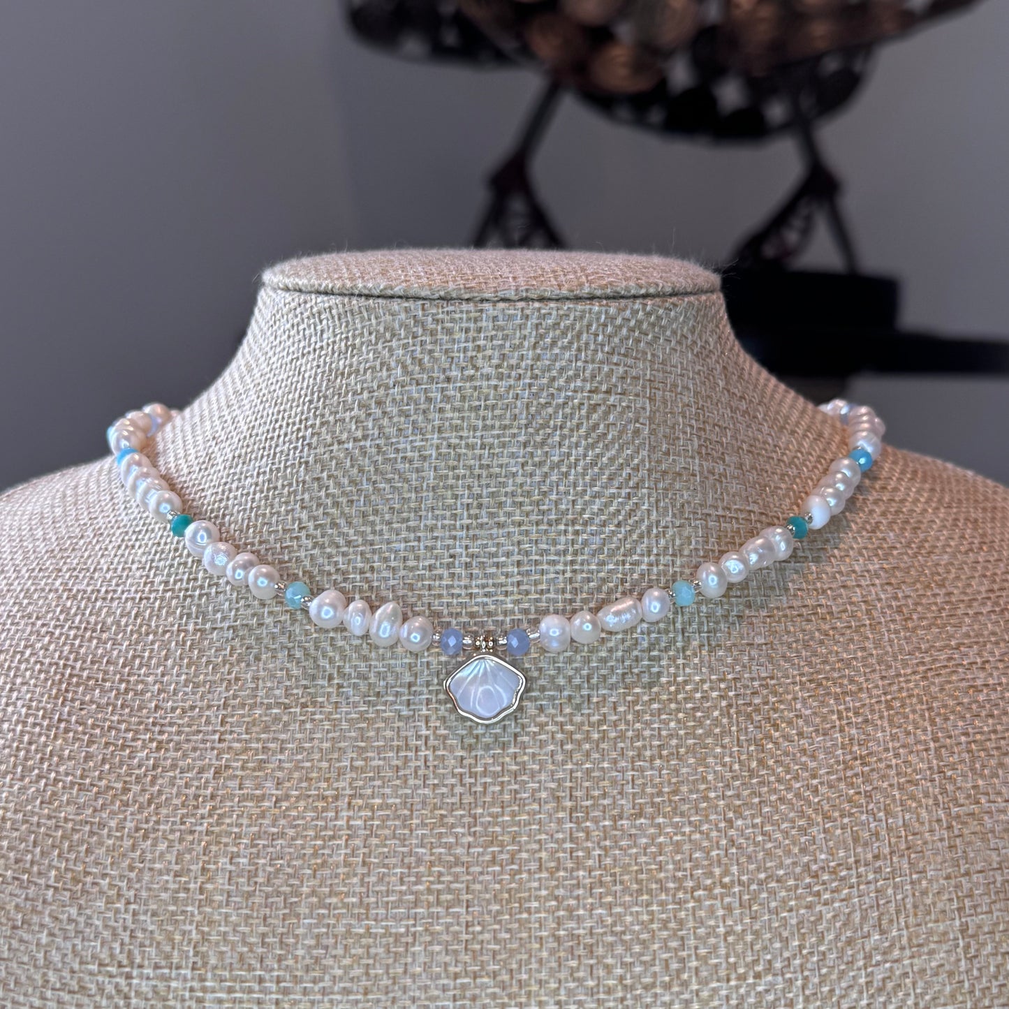fresh water pearl necklace with blue hues natural crystals and a shell shape pendant