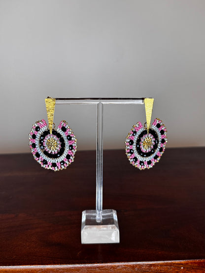 A pair of Spark Earrings displayed on a stand, featuring a hypoallergenic German silver stud and blue acrylic crystals in a circular beaded design.