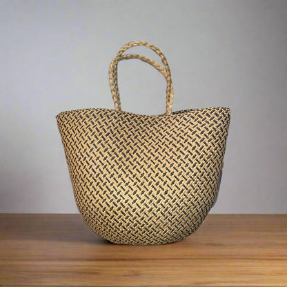 Woven straw bag on a wooden surface with a gray background