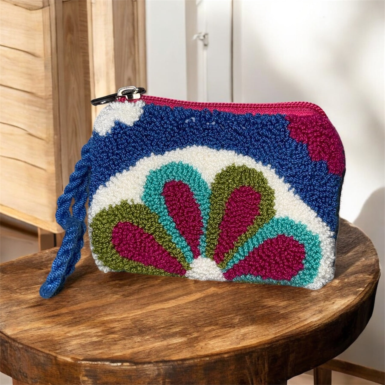 Colorful handcrafted pouch with floral design on a wooden surface