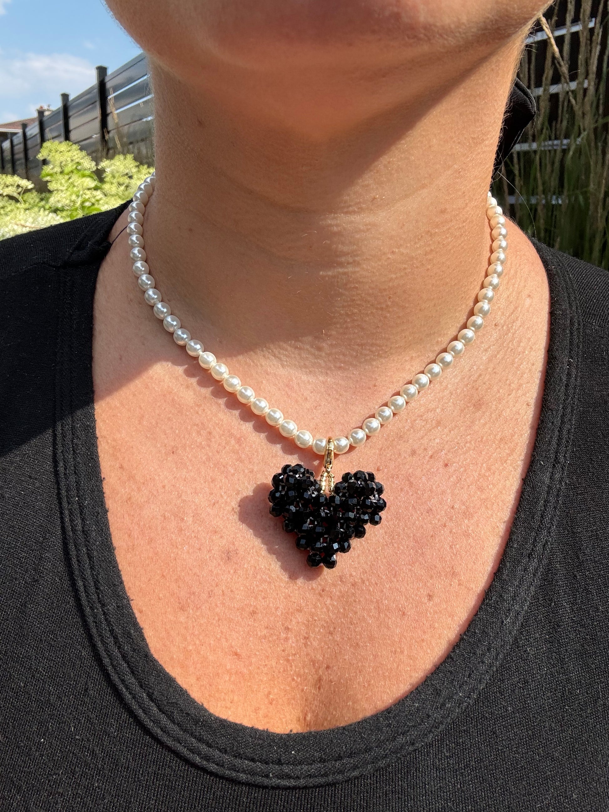 pearl necklace and black heart accessory.