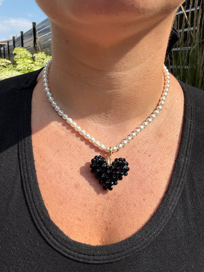 pearl necklace and black heart accessory.