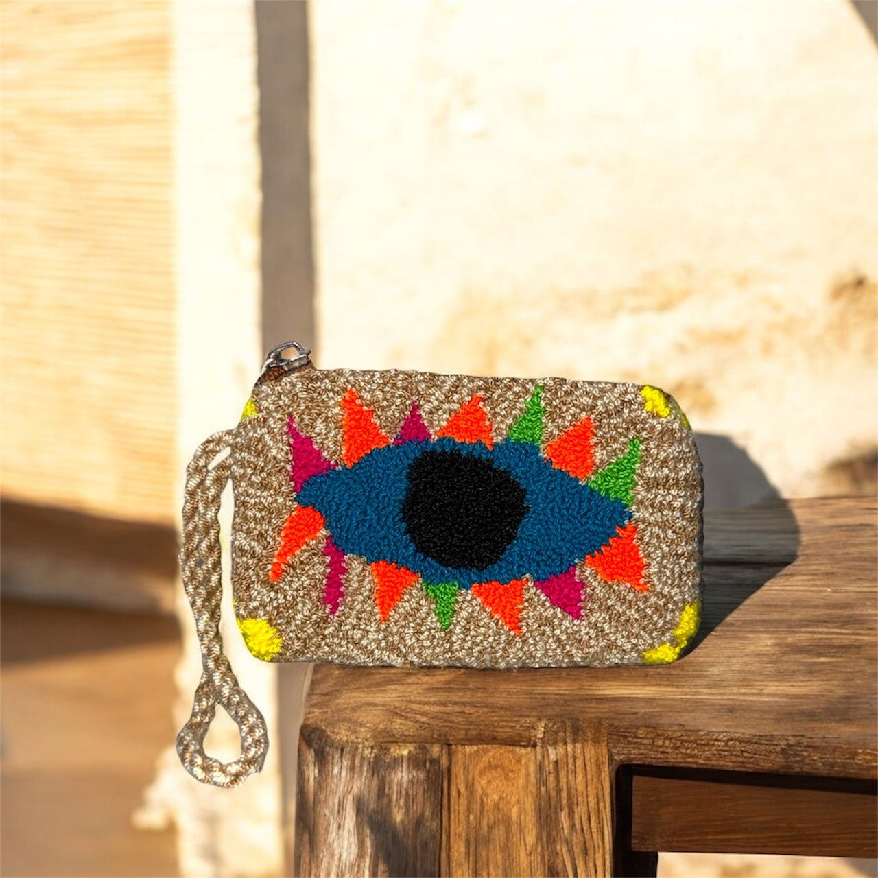 Colorful eye-shaped clutch bag on a wooden surface with a blurred natural background Montreal 