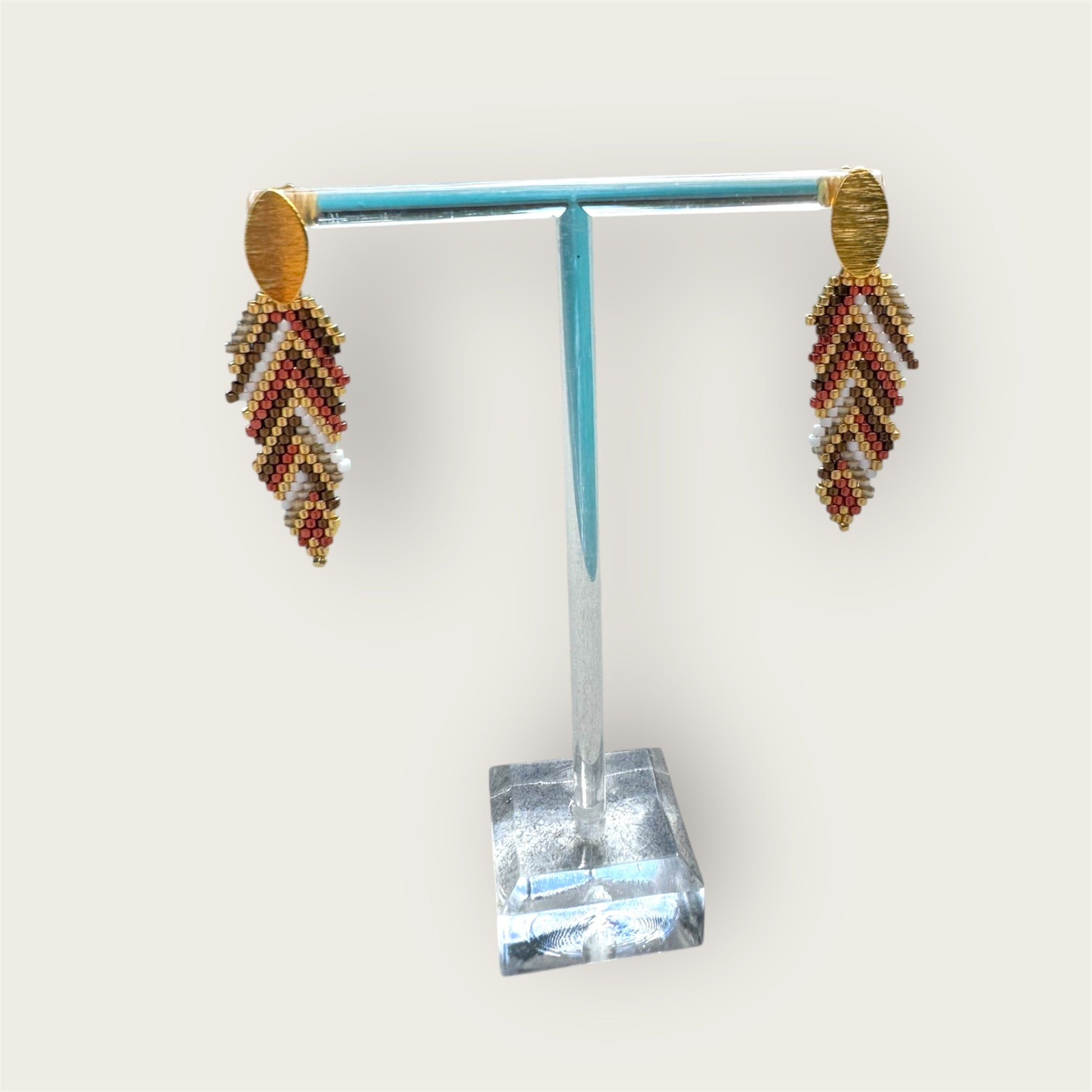 Beaded earrings on a stand with a white background
