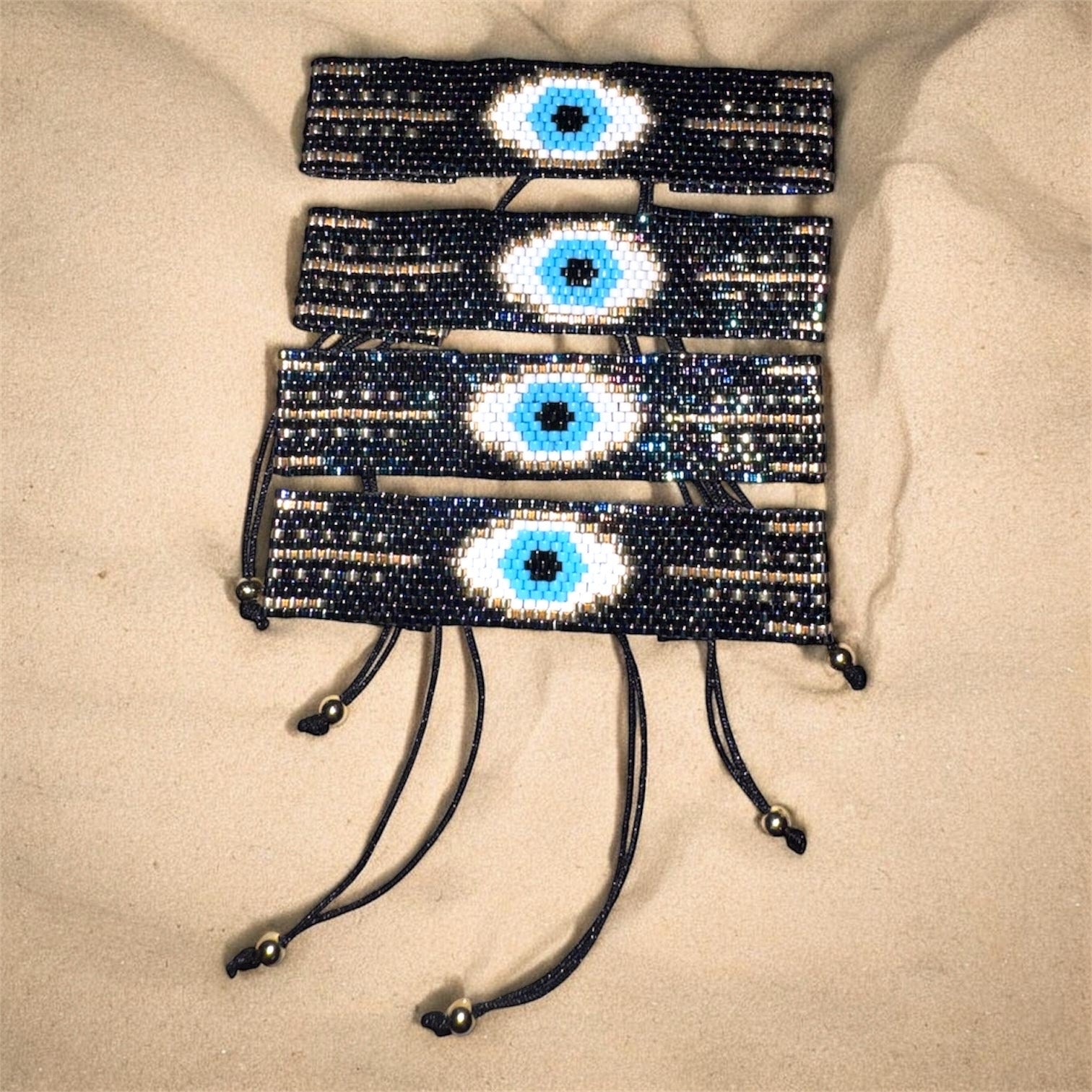 bracelets with eye designs on a beige surface