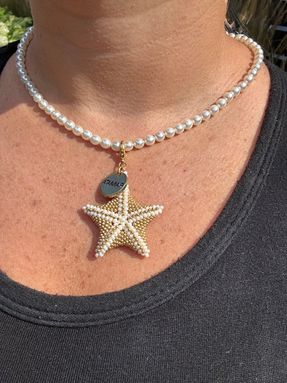 Pearl necklace with a starfish pendant worn by a person