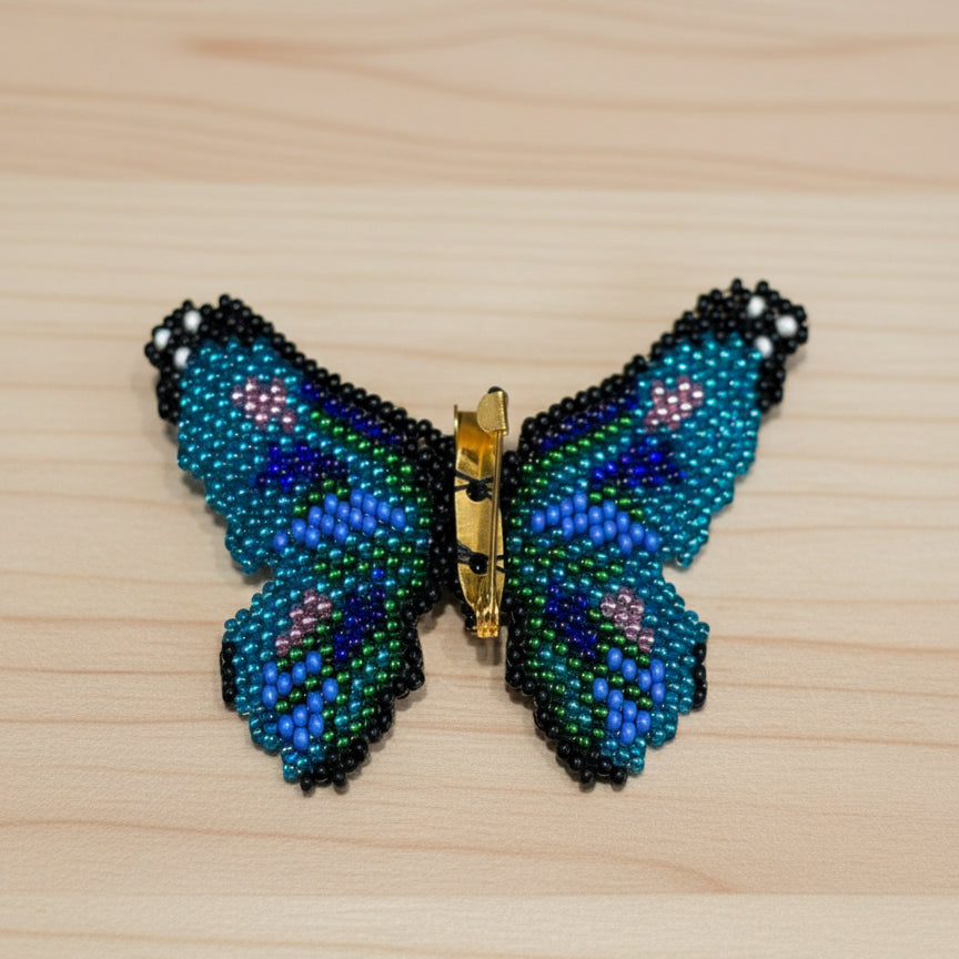 Butterfly-shaped hair clip with beadwork on a wooden surface