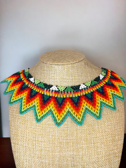 A colorful handmade acrylic bead necklace displayed on a mannequin.