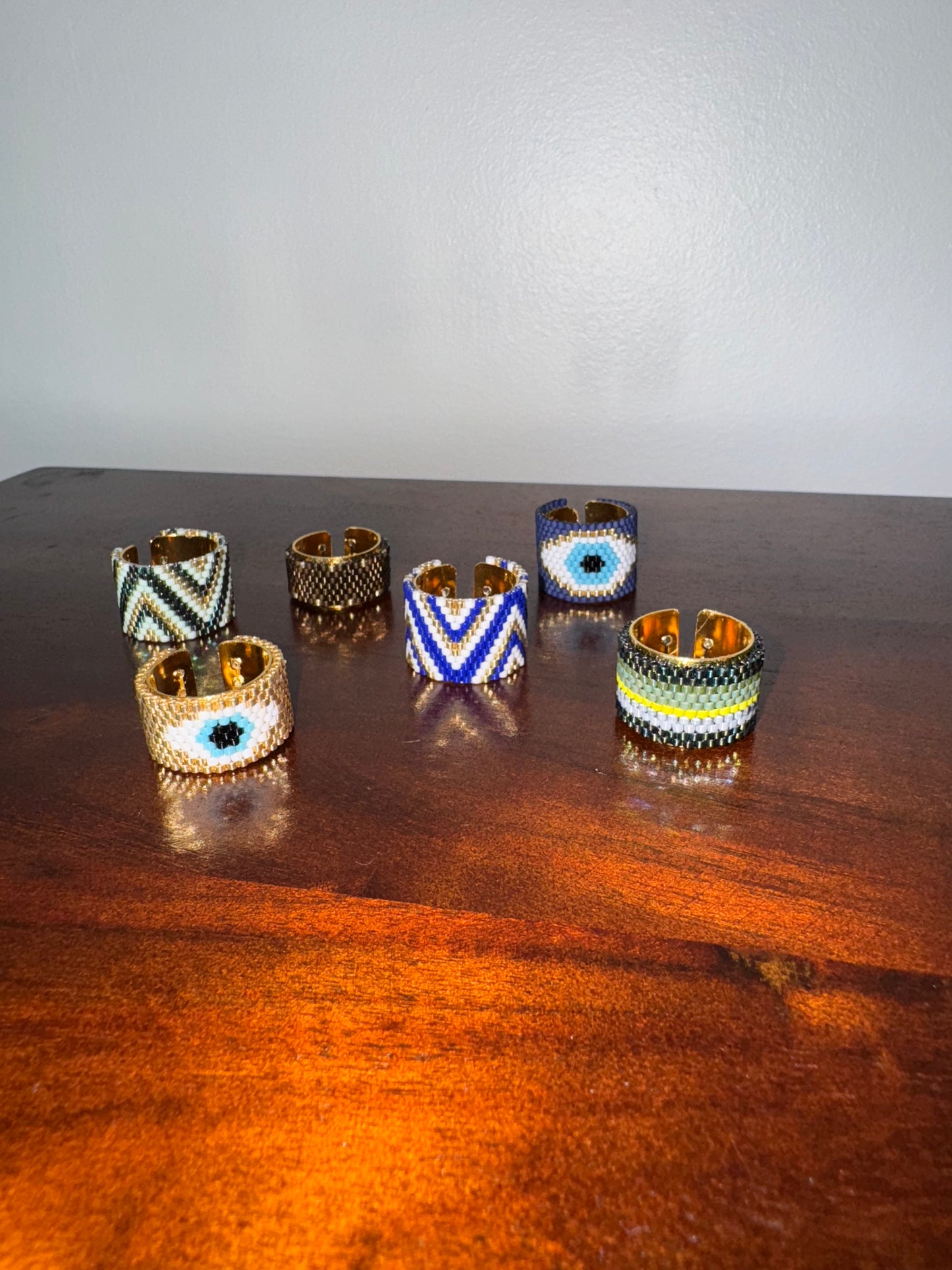 Set of six decorative rings on a wooden surface with a plain background