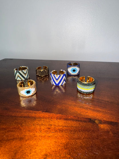 Set of six decorative rings on a wooden surface with a plain background