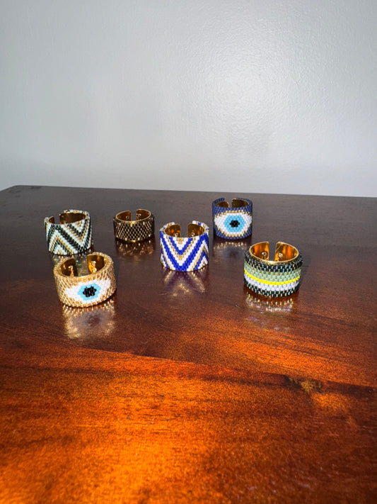 Set of six decorative rings on a wooden surface with a plain background