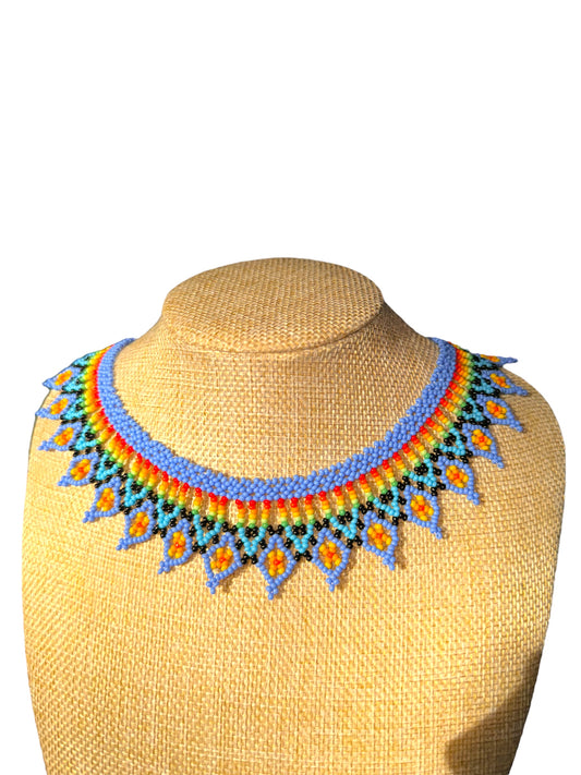 A colorful beaded necklace displayed on a mannequin bust, featuring a vibrant mix of pastel colors.
