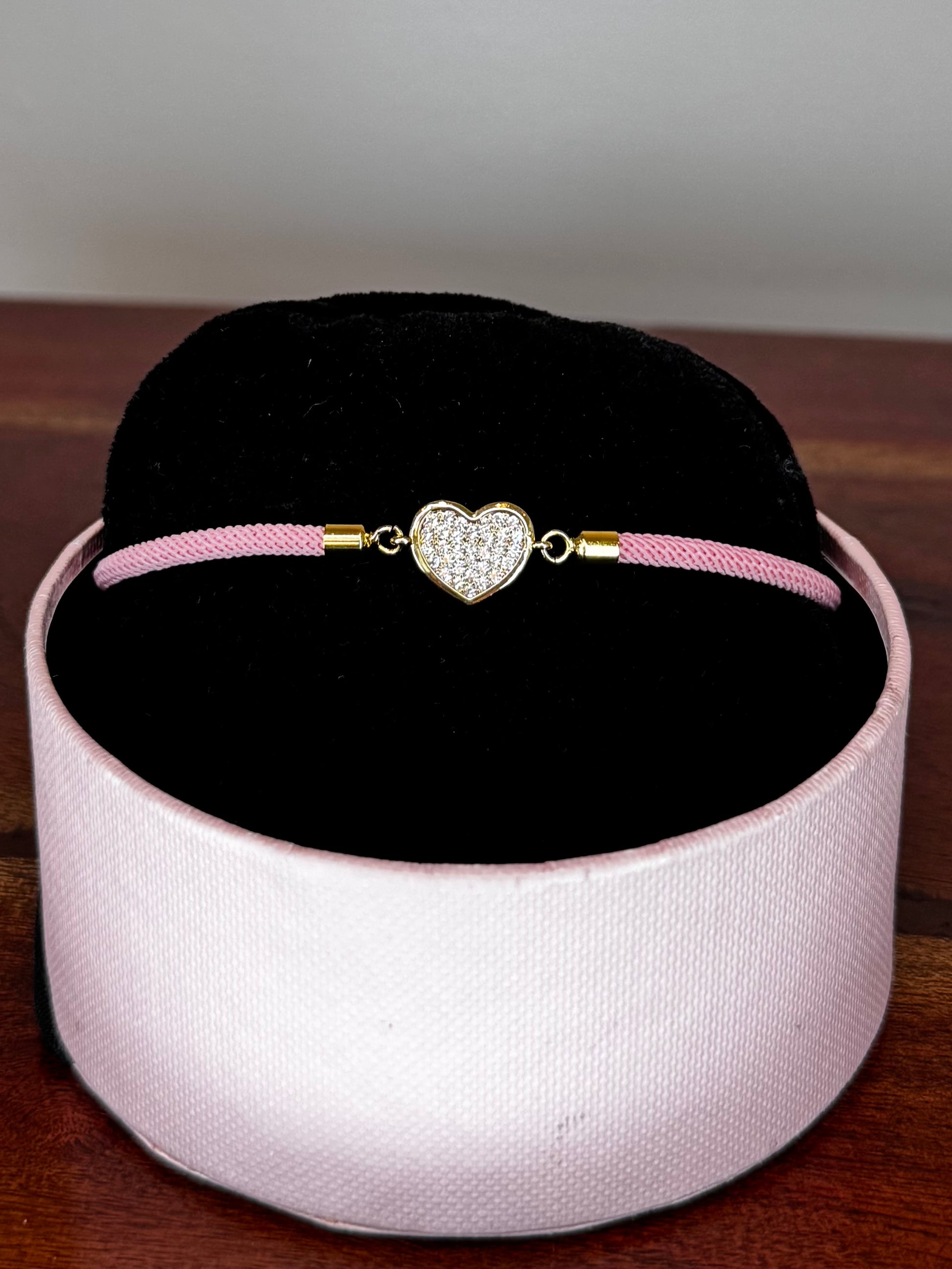 Pink bracelet with a heart-shaped charm 