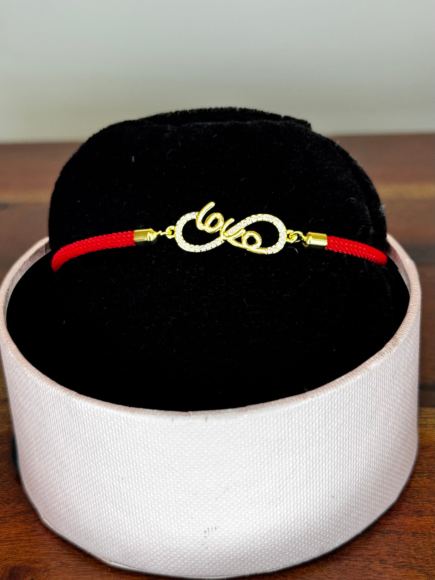 Gold bracelet with red cord 