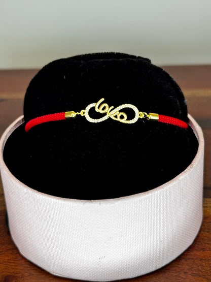 Gold bracelet with red cord 