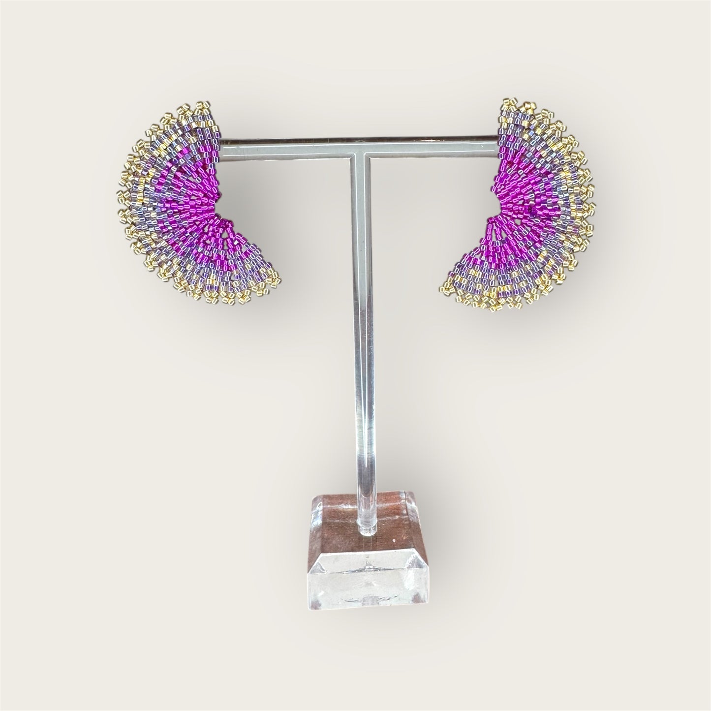 Pair of earrings on a display stand with a white background