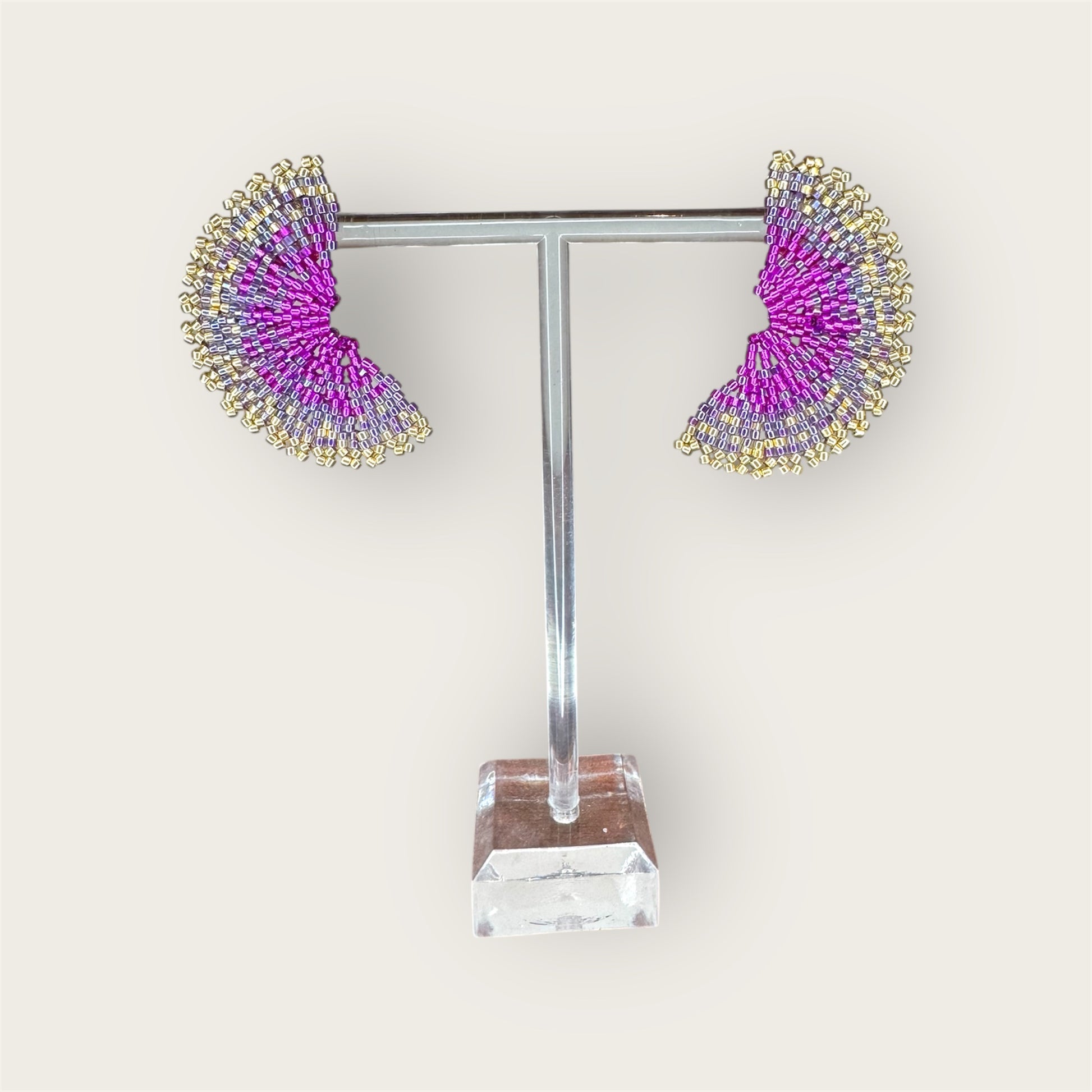 Pair of earrings on a display stand with a white background