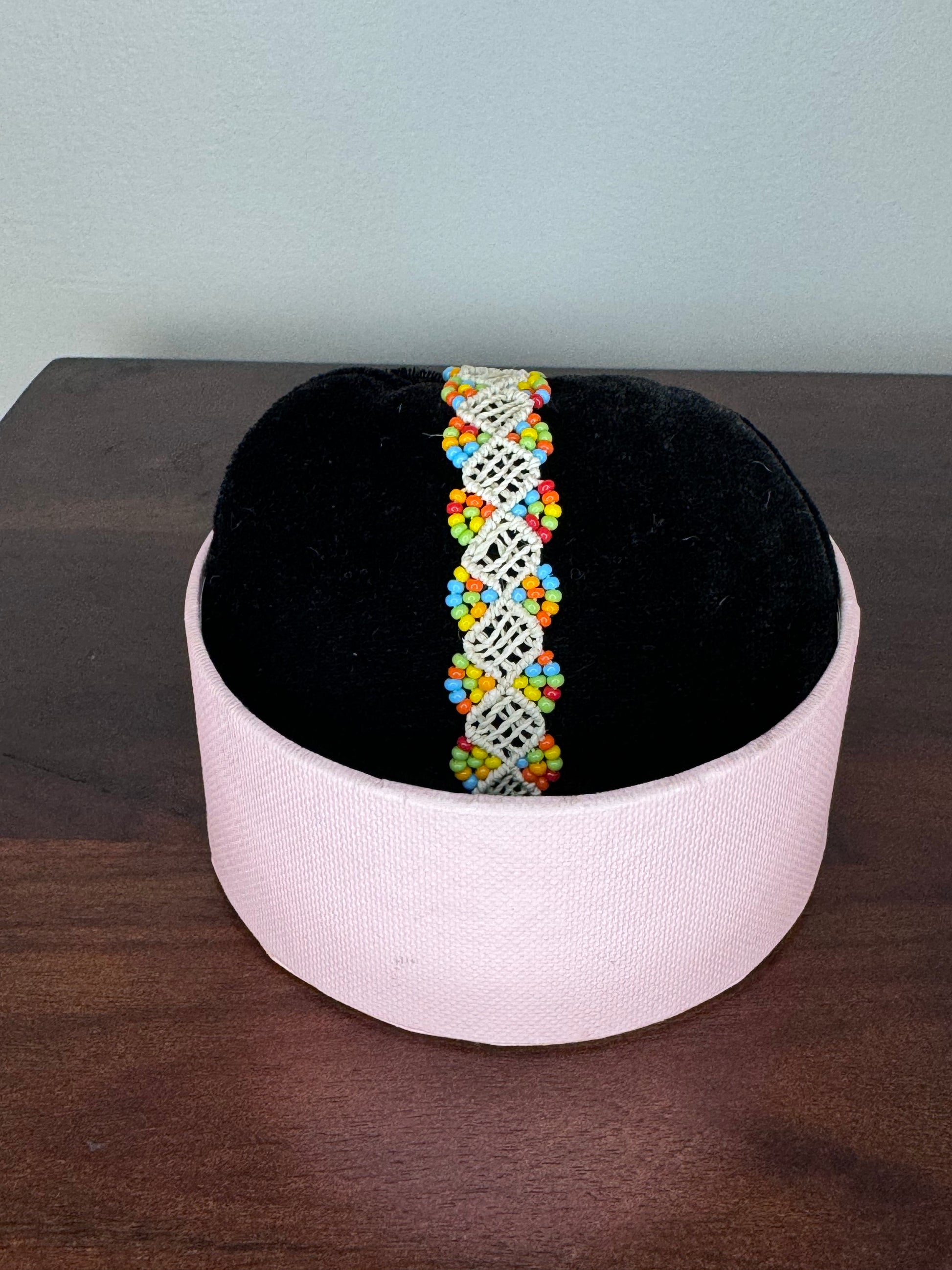 A series of three bracelets with geometric patterns, featuring a variety of colorful beads.