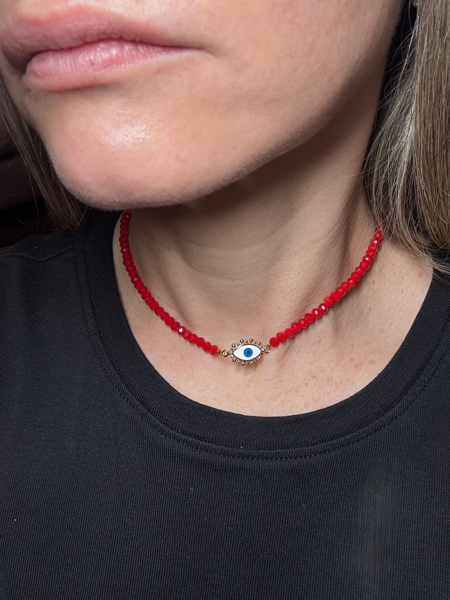 red beaded necklace with an eye pendant.