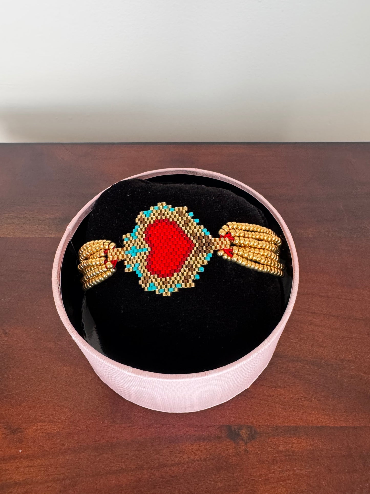 A bracelet with a heart-shaped centerpiece, woven from colorful beads, 