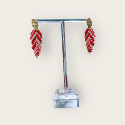 Chevron patterned earrings on a clear stand with a white background
