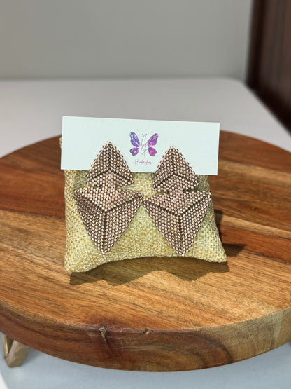 Gold bow-shaped earrings on a card with a triangle design