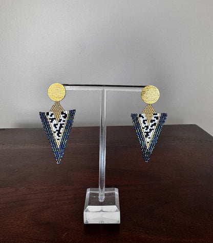 A pair of handcrafted Miyuki earrings with a long-triangle design, featuring gold-colored circles at the top and a pattern of black and white beads