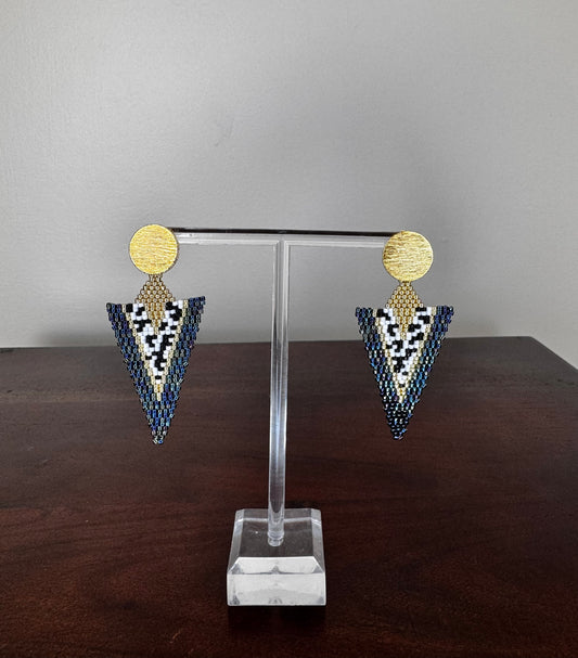 A pair of handcrafted Miyuki earrings with a long-triangle design, featuring gold-colored circles at the top and a pattern of black and white beads