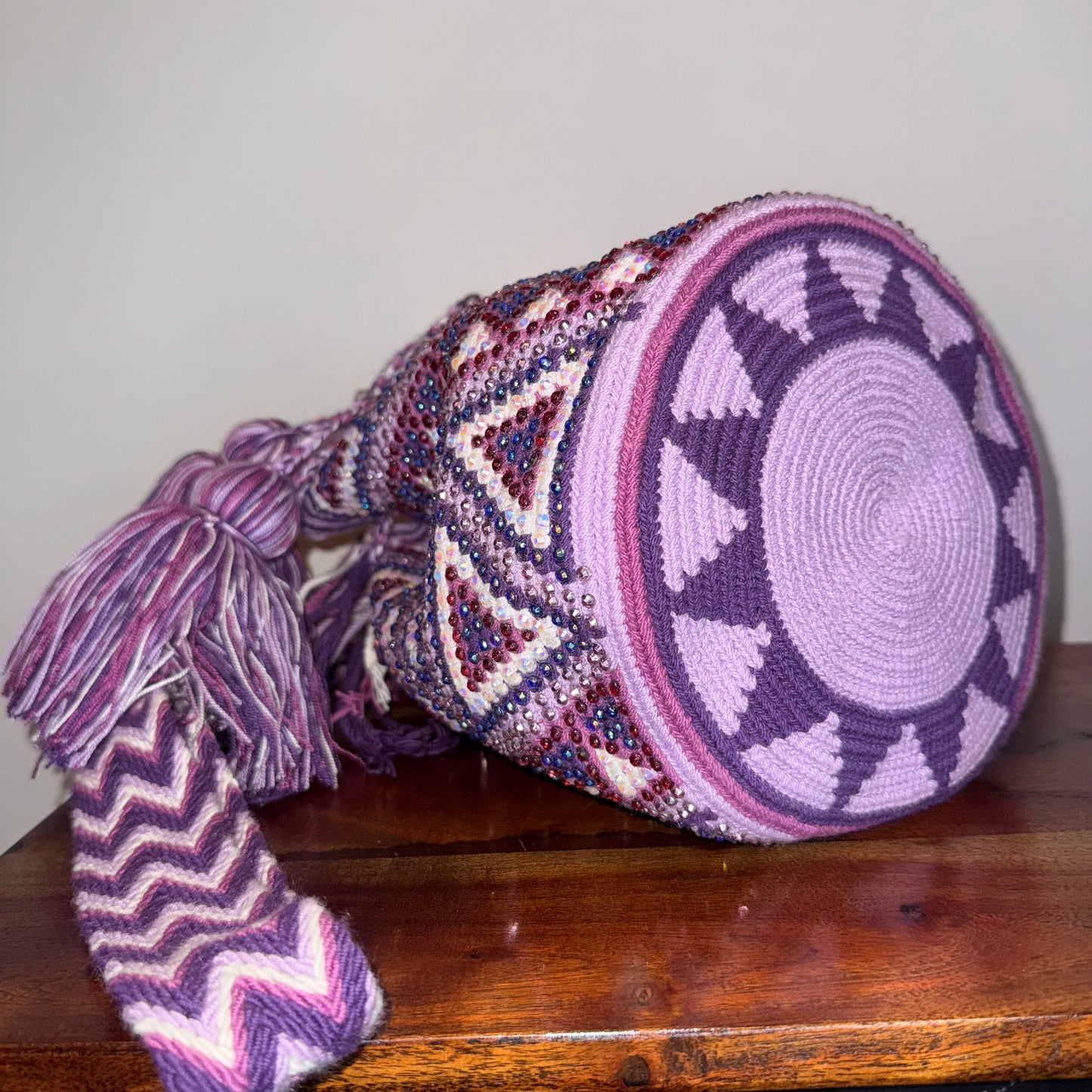 Decorative woven basket with geometric patterns on a wooden surface