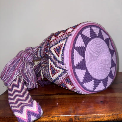 Decorative woven basket with geometric patterns on a wooden surface